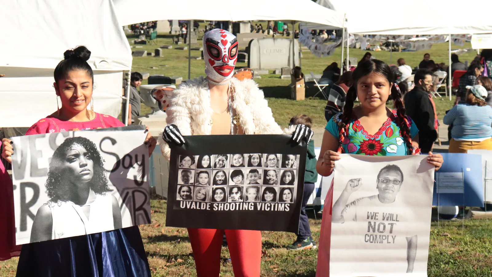 Three people holding photos of gun violence victims