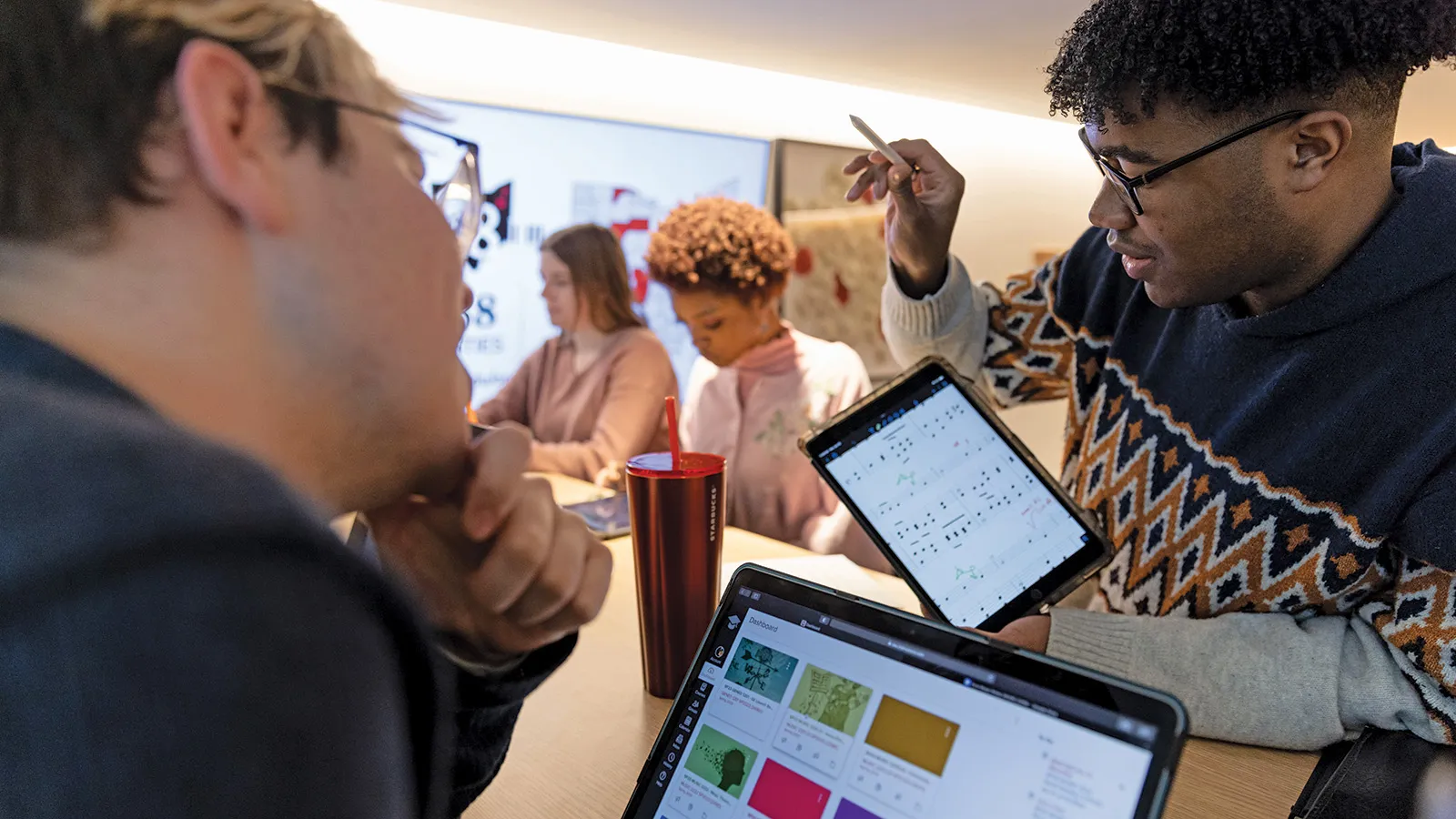 Students work together in class with iPads