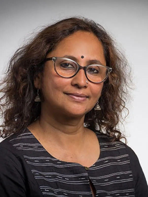 A woman with curly hair and glasses